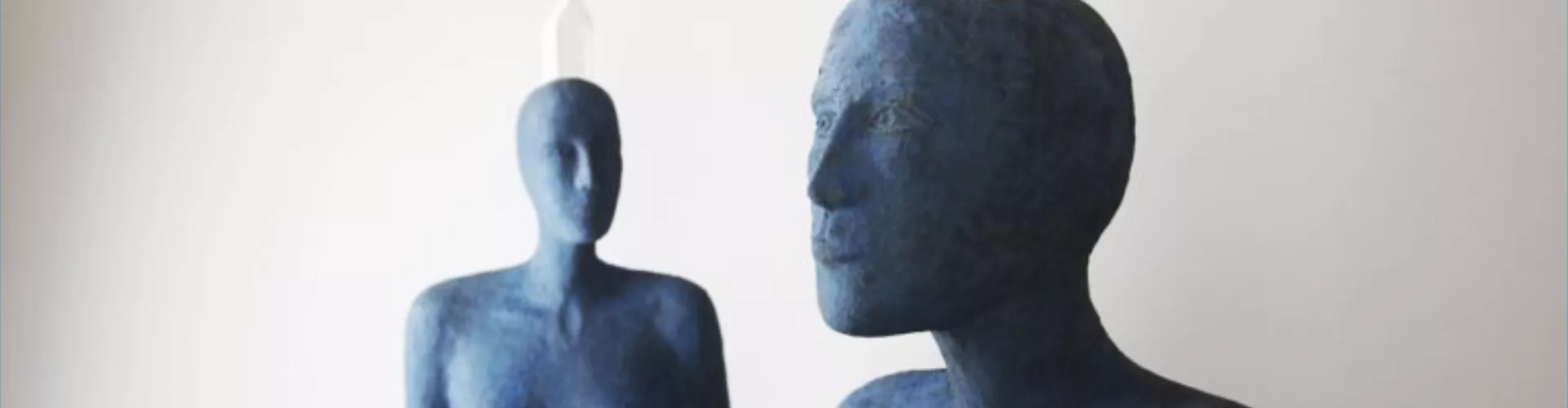 Sculpture de l'artiste Josette Taramarcaz, repésentant des corps bleutés avec une pierre blanche en équilibre sur leur tête